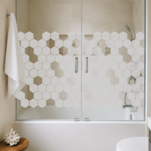 Mampara de vidrio con esmerilado de hexágonos, ideal para baños modernos y luminosos.